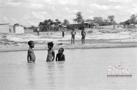This is a black and white image of children swimming at a water hole in Braklaagte. Image also used in the Land Act Virtual exhibition