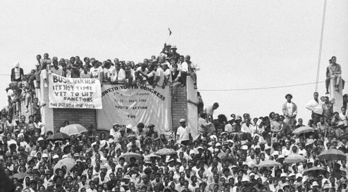 Youth sitting on top of a high wall during a welcome home Rally for Mr Nelson Rolihlahla Mandela in Soccer City, 1990-02-13 AL2878_H01.31