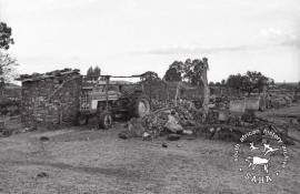 This black and white photograph of a tractor in front of a house destroyed during the forced removals in Mogopa was taken by Gille de Vlieg in February 1984. Included in SAHA Land Act Project report, 2014.