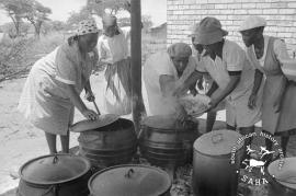 This black and white photograph of Mogopa women living in Onderstepoort serving food for guests was taken by Gille de Vlieg on 19 February 1984. Included in SAHA Land Act Project report, 2014.