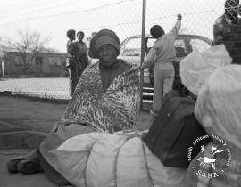 This black and white photograph of a woman in Ikagaleng waiting to return to Braklaagte was taken by Gille de Vlieg in July 1991. This image was digitised by Gille de Vlieg. Included in SAHA Land Act Project report, 2014.