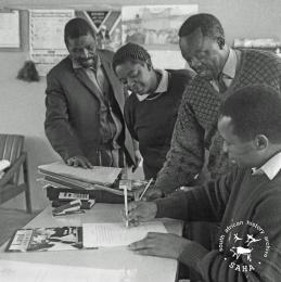This black and white photograph of a group of people signing a document requesting more land in Driefontein was taken by Gille de Vlieg in September 1995. Included in SAHA Land Act Project report, 2014.