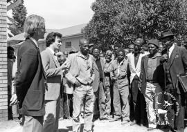 This black and white photograph of Geoff Budlender talking to Driefontein residents outside the court in Volksrust was taken by Gille de Vlieg in 1984. Included in SAHA Land Act Project report, 2014.