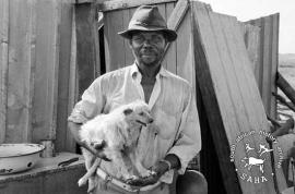 This black and white photograph of a man with his dog, standing outside his newly built home in Barseba was taken by Gille de Vlieg in March 1984. This photograph was digitised by Africa Media Online (AMO) in 2009. Included in SAHA Land Act Project report, 2014.