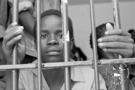 This black and white photograph of a youth behind bars after being arrested by Bophuthatswana police was taken by Gille de Vlieg on 27 March 1989. This photograph was digitised by Africa Media Online (AMO) in 2009. Included in SAHA Land Act Project report, 2014.