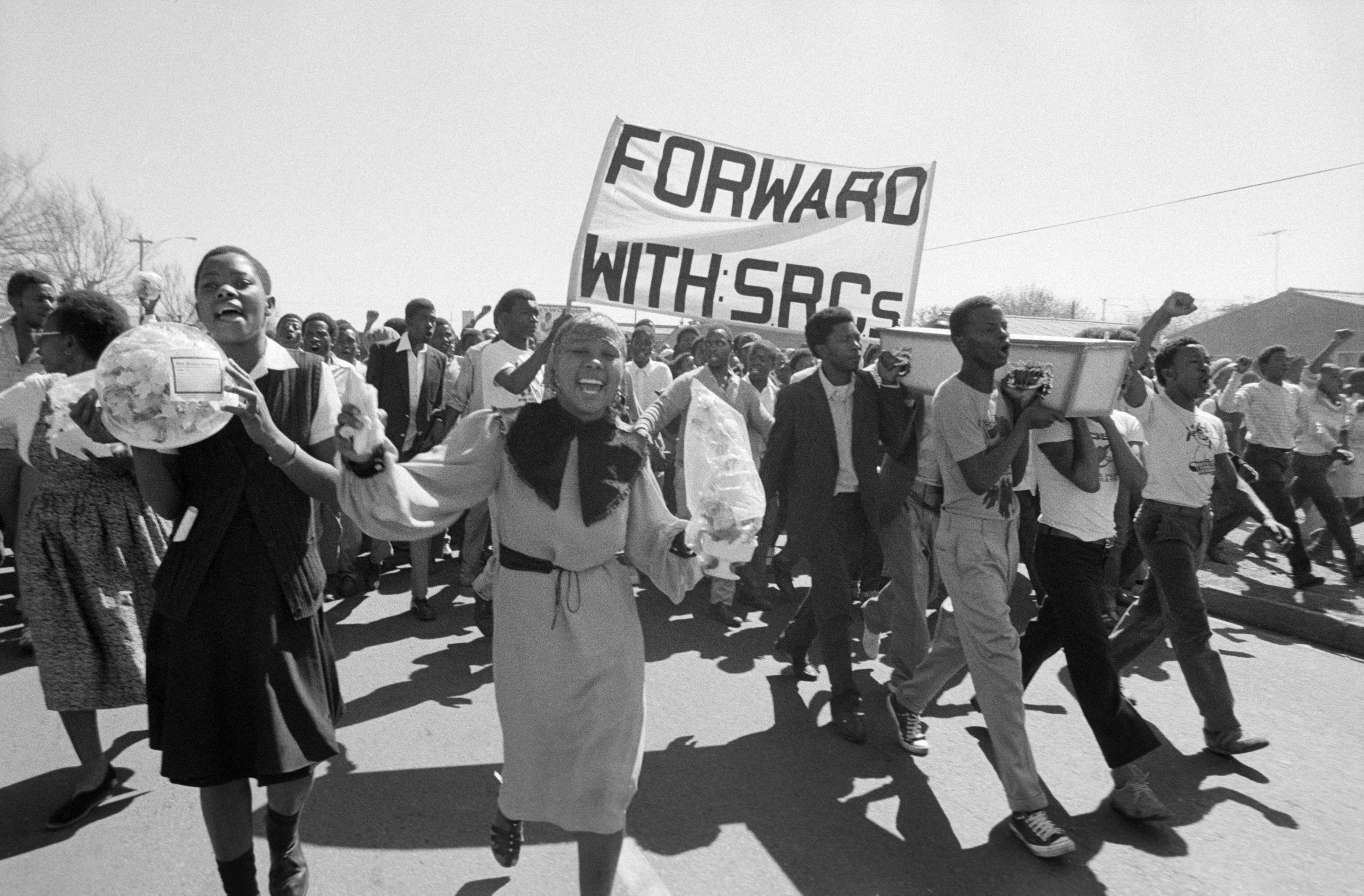 Students marching to cemetery with grave flowers, Wattville, Gauteng, 1984-09-09. Photograph by Gille de Vlieg. Archived as SAHA collection AL3274_B22.2