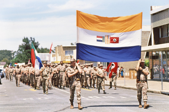 AWB storm troopers carrying the South African flag during a right-wing rally in Klerksdorp in 1993. Photographer: Doug Lee. Archived as SAHA collection AL3283_C01_117_06